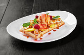 Belgian waffle with fruits, berries and vanilla ice cream, topped with caramel sauce