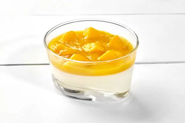 Photo of Vanilla panna cotta with mango puree and fresh fruits in glass