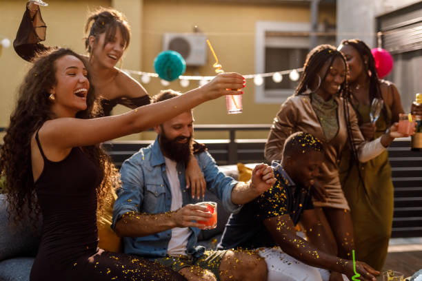 istock Cheering with their drinks after popping gold colored confetti 1703819239