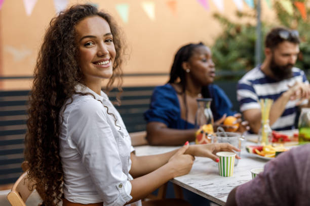 istock Charming young woman smiling at camera while hanging out with friends 1703827970