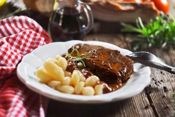Photo of Pasticada with gnocchi, beef stew in a sauce. Croatian cuisine