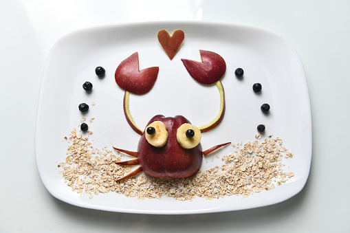 Apple And Oatmeal With Berries And Banana Slices Shaped As A Crab