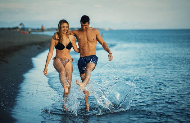 istock Young couple walking on the beach at sunset. 1703846258