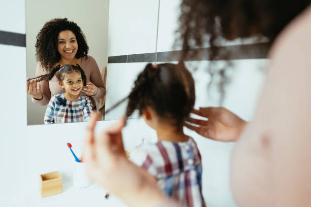 istock Mother and daughter in bathroom, washing hands and face 1703846845
