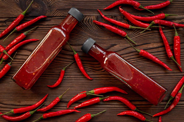 istock Red chili sauce ketchup or tabasco with ripe hot pepper 1703850107