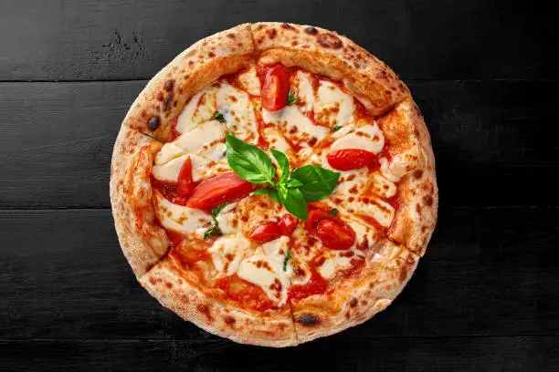 Photo of Italian pizza Margherita with tomatoes, mozzarella and fresh basil