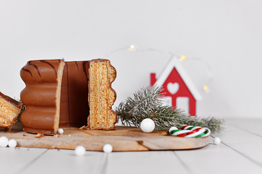 Cut open cake called 'Baumkuchen', a German layered cake glazed with chocolate, surrounded by seasonal decoration