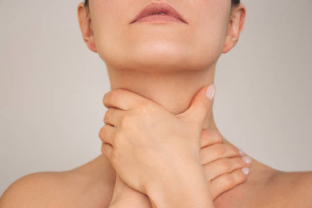 istock woman holds her neck with both hands, suffering from a sore throat 1703880458