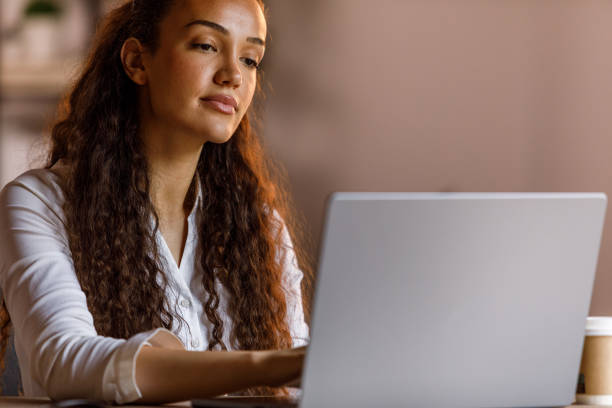 istock Diligent young woman using laptop at her desk 1703892565