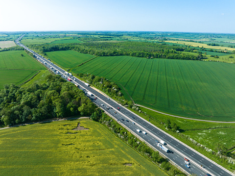An aerial view of a straight section of the M1 motorway through the English Midlands.