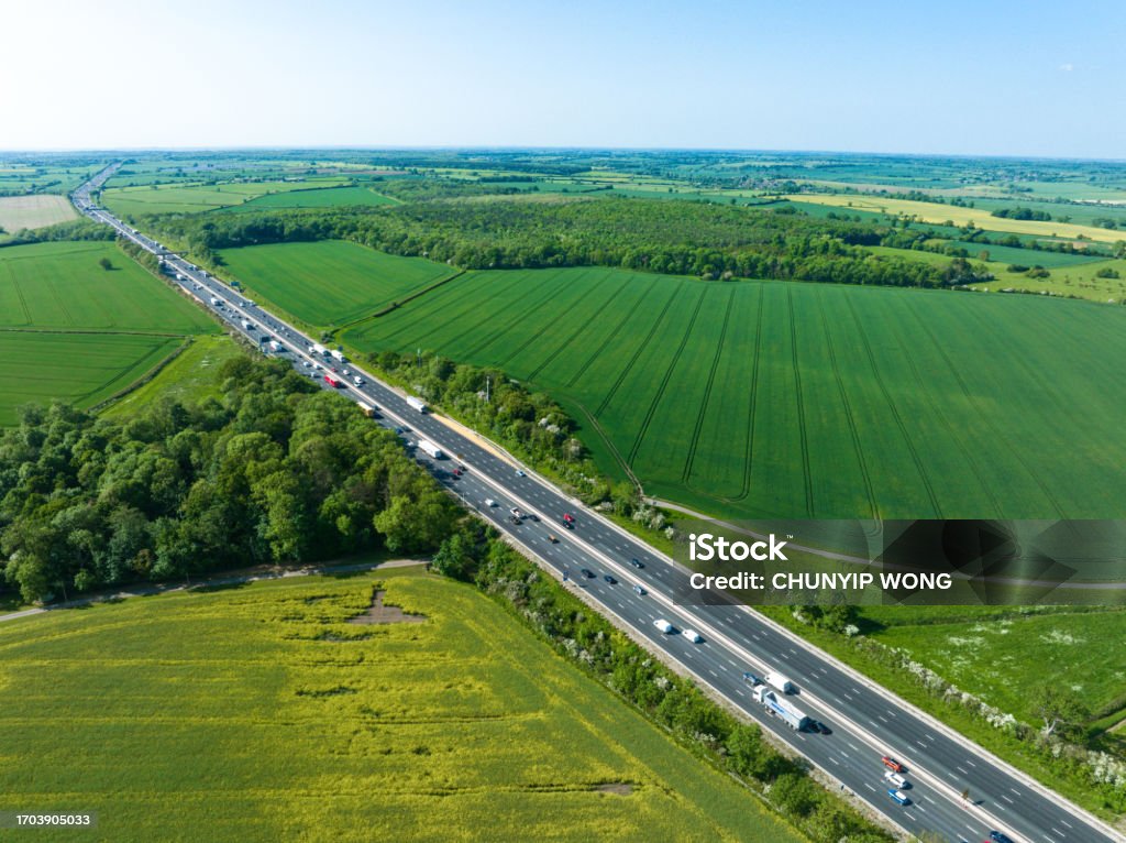An aerial view of a straight section of the M1 motorway through the English Midlands. Agricultural Field Stock Photo