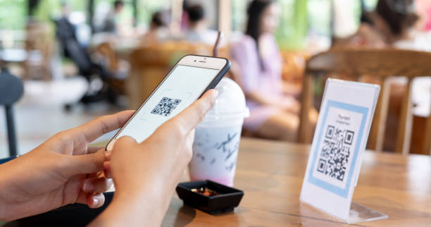 istock Woman use smartphone to scan QR code for order menu in cafe restaurant with a digital delivery. Choose menu and order accumulate discount. E wallet, technology, pay online, credit card, bank app. 1703920063