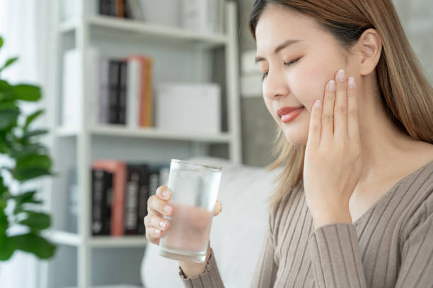 istock Asian woman feel sensitive teeth after drinking cold, female suffer tooth, decay problems, dental care, tooth extraction, decay problem, bad breath, Gingival Recession, Oral Hygiene instruction 1703921138