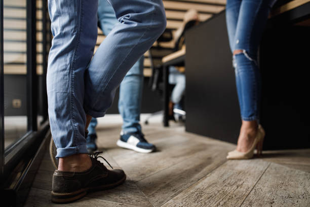 istock Low section of people standing in office space and chatting during work break 1703924902