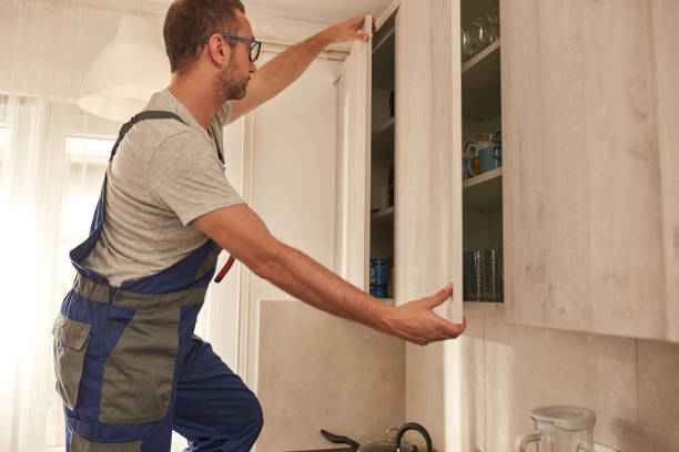istock Handyman fixing kitchen cabinets in the apartment. 1703928805