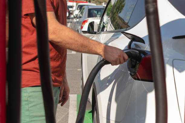 istock Man charging electric vehicle on a public charger. 1703930357