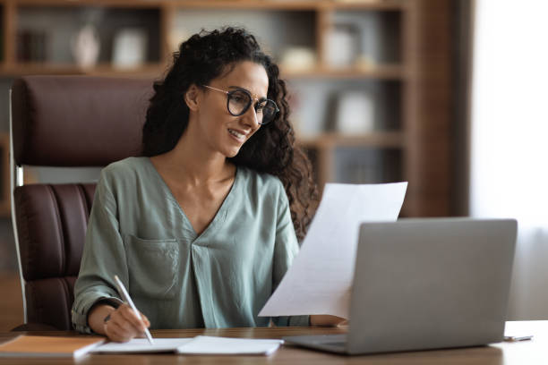 istock Pretty young businesswoman working at office, copy space 1703935329