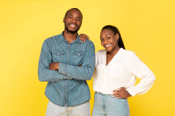 istock Cheerful Black Couple Posing Together Over Yellow Background 1703935902