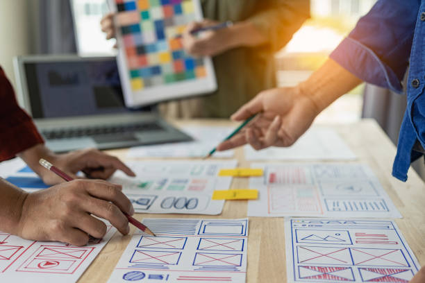 istock A team of UI UX web designers is working together to develop a mobile responsive website by previewing UI UX Front End Designer website development ideas. 1703936490