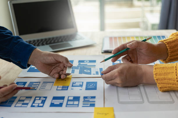 istock A team of UI UX web designers is working together to develop a mobile responsive website by previewing UI UX Front End Designer website development ideas. 1703937090