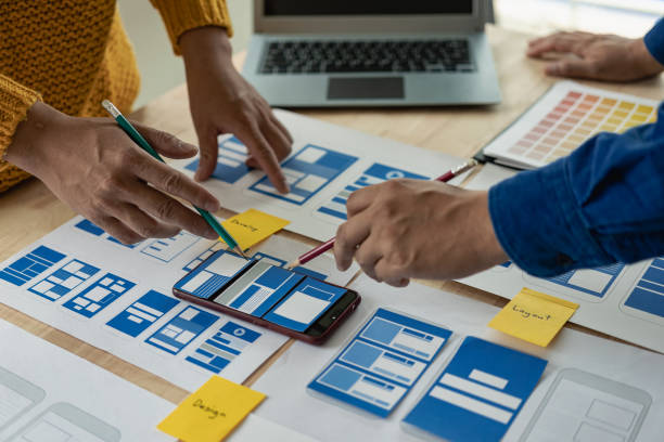 istock A team of UI UX web designers is working together to develop a mobile responsive website by previewing UI UX Front End Designer website development ideas. 1703937126
