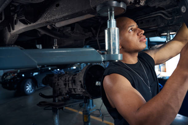 istock Auto-mechanic checking car-lift before lifting automobiles for maintenance 1703942967