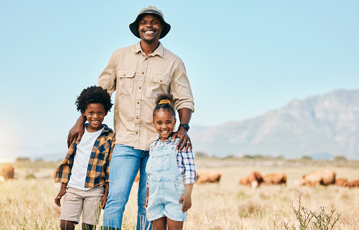 Family, portrait and people with animals in nature on holiday, travel and adventure in safari. African man and kids outdoor on a field in countryside with a smile on farm trip in Africa with freedom