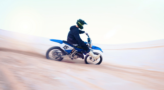 Sports, desert and athlete on motorbike for action, adrenaline and skill training for challenge, Fitness, sand dunes and man biker practicing for race, competition or performance adventure at a rally
