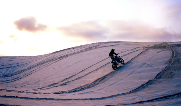 sand, desert or athlete with motorcycle for action, adventure or fitness with performance for adrenaline. sunset, sports or person on motorbike on dunes for training, exercise or race or challenge - driving training car safety imagens e fotografias de stock