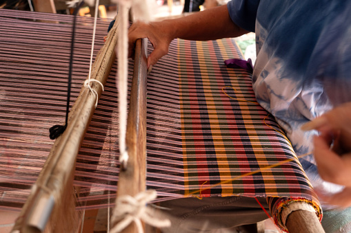 The traditional weaving of handmade cotton on the manual wood loom in Thailand.Close-up weaving cotton.