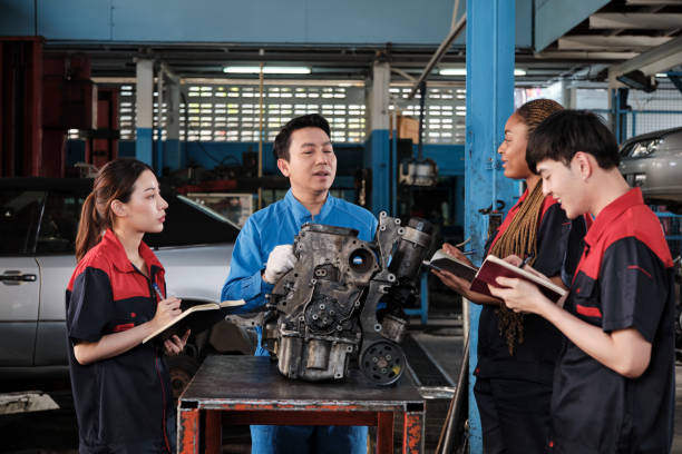 istock Supervisor engineer is teaching mechanic workers about car engines at a garage. 1704002007