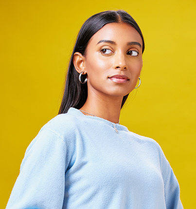 Beauty, fashion and confidence with an indian woman on a yellow background in studio for trendy style. Mindset, pride and clothes with a young gen z model posing in clothes outfit for a magazine