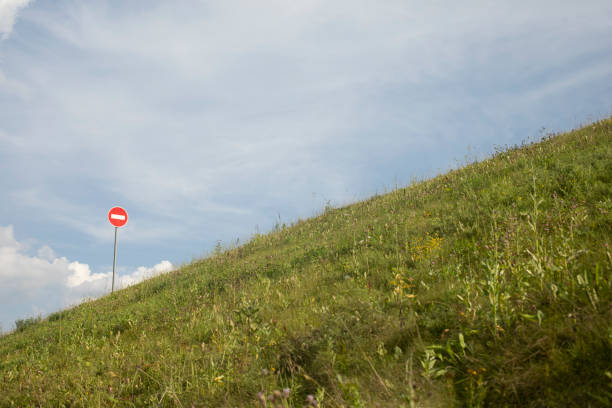 Stop sign on mountain. Road sign on hill. Round plate. Green Holi.