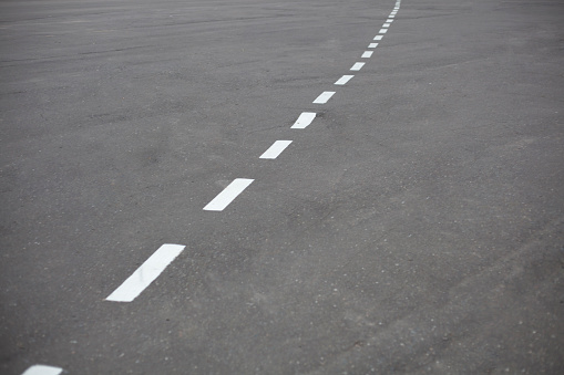 White marking lines on asphalt in an empty parking lot, outdoors.