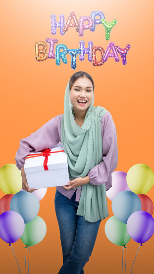 Asian woman in a veil presents a gift box while celebrating a birthday party. Happy Birthday Woman concept