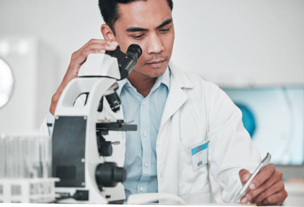 実験室でのdnaの医学的分析のためのレポート、テスト結果、研究データを書く科学者、顕微鏡、男性。バイオテクノロジー、科学、医師、チェックリスト、文書、またはヘルスケア研究 - genetic research chemist writing science ストックフォトと画像