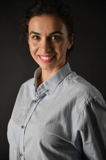 istock Smiling Female In Blue Shirt On Black Background 1704032835