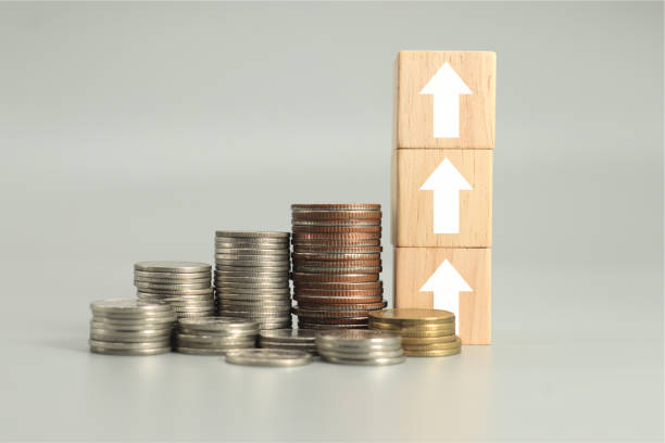 istock wooden cube box arrow with stack coins.financial management. 1704042477