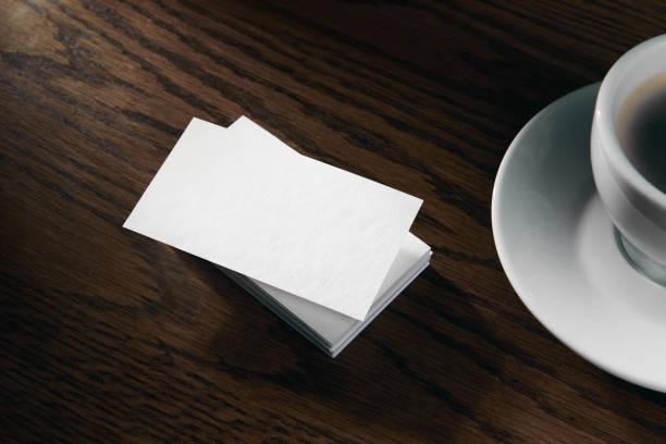 istock Modern business card mockup template with copy space. Design presentation layouts for corporate identity, advertising, personal, stationery on table with coffee cup. 1704050257