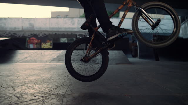 Active bmx biker jumping on bicycle oundoors. Guy performing jump stunt.