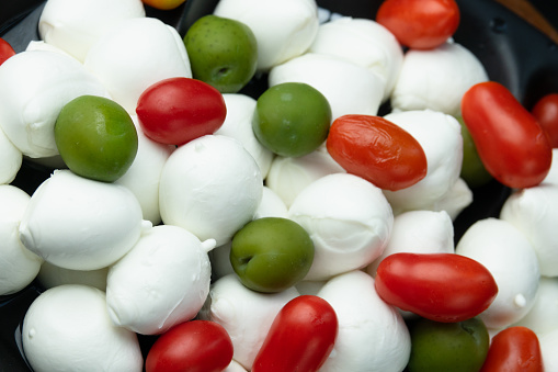 Morsels of buffalo mozzarella with olives and tomato