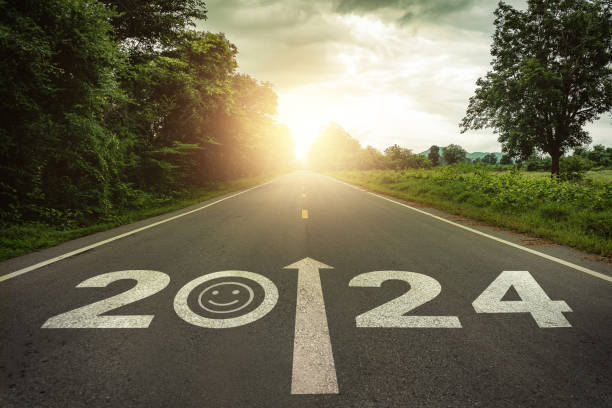 istock Happiness in  New Year 2024 or straightforward concept. Text 2024 and smiley face written on the road in the middle of asphalt road at sunset. Happiness, optimistic, challenge, hope, new life change. 1704112336