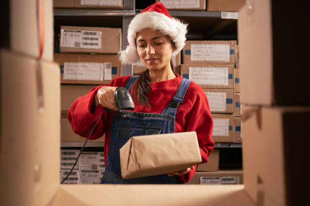 istock Manager scanning barcode on delivery parcel. Female worker scan barcode of cardboard packages before delivery at storage working in warehouse using scanner for labels on the boxes 1704115274