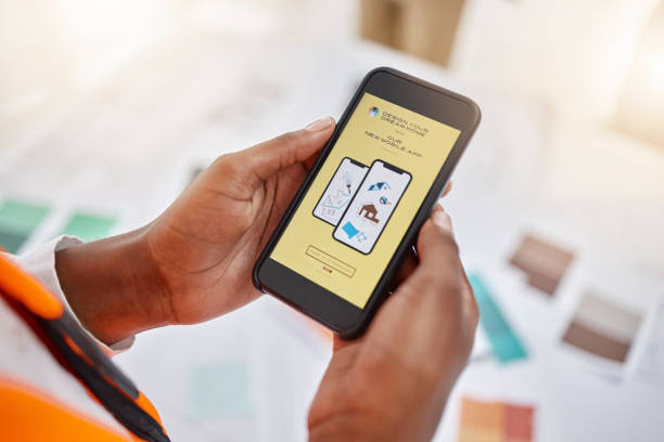 istock Phone, hands and creative with an architect in the office closeup from above for home design. Mobile, architecture and tutorial with a designer reading information while planning a house renovation 1704167533