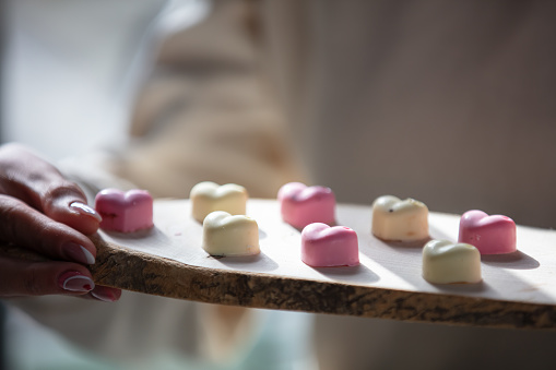 A woman is serving a heart shaped chocolate at cafe.