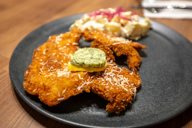Chicken schnitzel serving with potato salad at fine-dining restaurant.