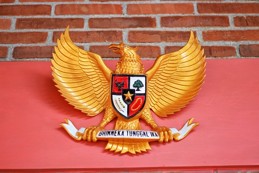 image of a wooden statue of Garuda Pancasila, the Republic of Indonesia's national symbol. The meaning of Bhinneka Tunggal Ika is \
