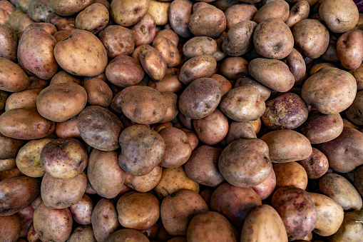Stack of papa pastusa or Colombian potatoes in the produce aisle at a supermarket