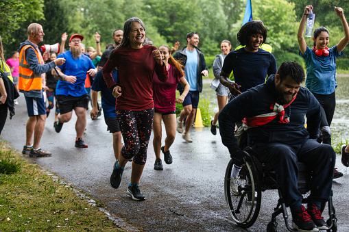 A group of run participants taking part in a fun run in Leazes Park in Newcastle upon Tyne, North East England. They are setting off together as a community group and it is raining. At the front of the group there is a wheelchair user. The race is open to people of all ages and abilities and is also dog friendly. 

These files have similar videos/images available.