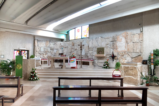 Rome, Italy: interior sight of the modern church with the altar in the left corner and a polychrome stained glass window.